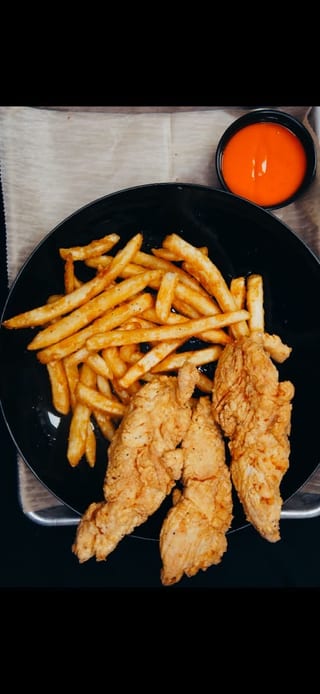 Breaded chicken tenders with fries and dipping sauce